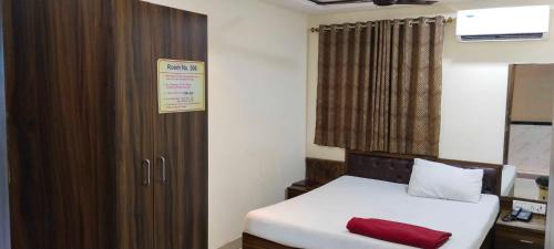 孟买Hansh Residency的小房间设有床和木柜