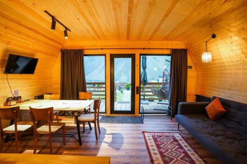 卡兹贝吉Kazbegi Spa Resort Cottages的客厅配有桌子和沙发