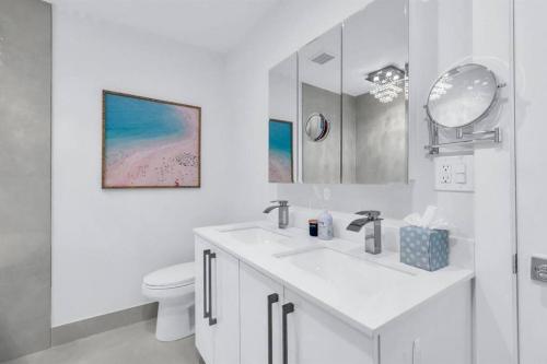 德尔雷比奇Luxury Designer Delray Beach. 10 Min to the Beach!的白色的浴室设有水槽和卫生间。