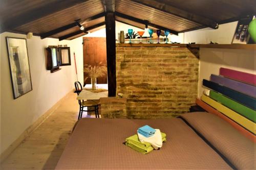 西尼加利亚Casale Barbagianni的一间卧室设有一张床和砖墙