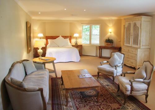 波拉尔米尔顿公园乡村度假屋酒店及Spa的配有床、椅子和桌子的酒店客房