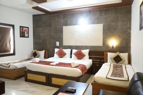 阿格拉Hotel Tara Palace by Goyal Hoteliers的酒店客房设有两张床和一张桌子。