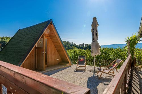 新梅斯托Vineyard Cottage Hočevar With Sauna - Happy Rentals的一个带遮阳伞、椅子和遮阳伞的庭院