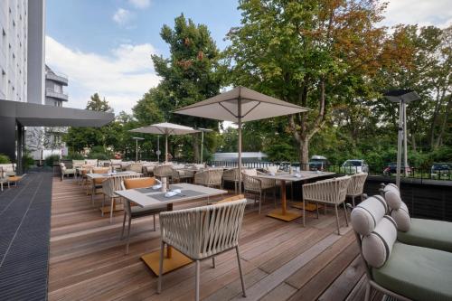柏林AC Hotel by Marriott Berlin Humboldthain Park的室外餐厅设有桌椅和遮阳伞。