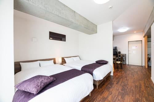 鹿儿岛STAYTUS - Vacation STAY 62201v的卧室设有两张床,拥有白色的墙壁和木地板