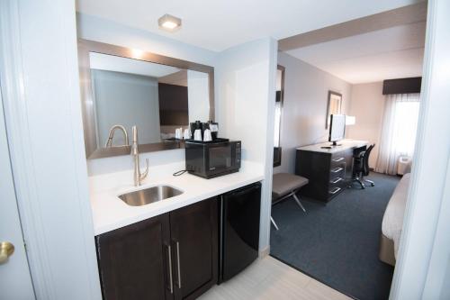 亚特兰大亚特兰大机场北费尔菲尔德客栈及套房的一间带水槽的浴室和一间带书桌的客房