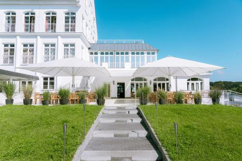 韦尔德Precise Resort Schwielowsee的建筑物前的两把白色遮阳伞