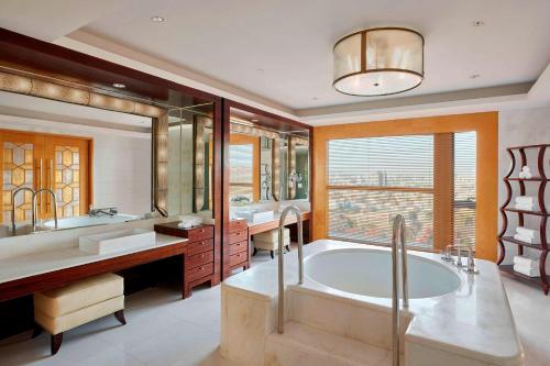 呼和浩特呼和浩特喜来登酒店的一间带大浴缸和大窗户的浴室