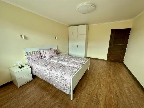 古尔贝内Swan City Family Apartment的一间卧室配有一张床,铺有木地板