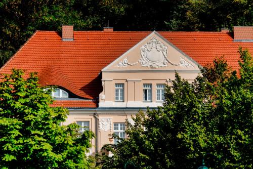 萨加尔德Precise Resort Rügen & SPLASH Erlebniswelt的一座有橙色屋顶的建筑,上面有狮子