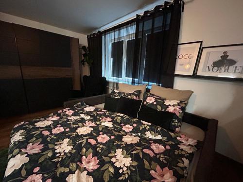 叶卡布皮尔斯OzolApart的一间卧室配有一张带花卉棉被的床