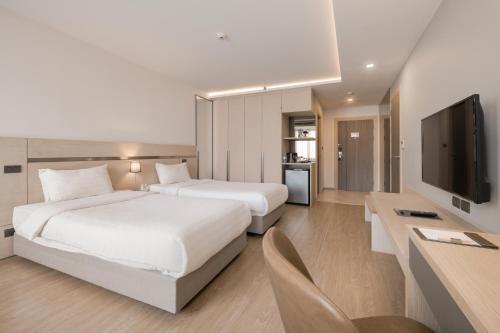曼谷三燕 赛琳 酒店的酒店客房设有两张床和一台平面电视。