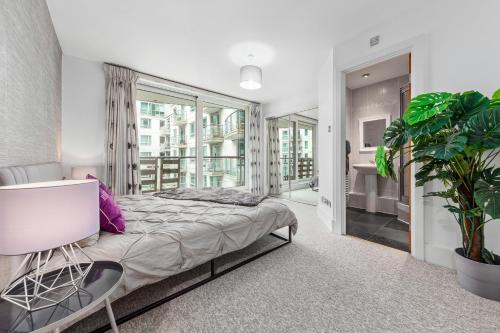 伦敦St, George Wharf Vauxhall Bridge large 2Bedrooms apartment with River View panoramic balcony的一间卧室配有床和植物