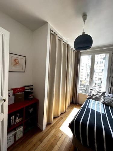 布洛涅-比扬古Appartement Confortable et Spacieux Boulogne-Billancourt的一间卧室设有一张床和一个大窗户