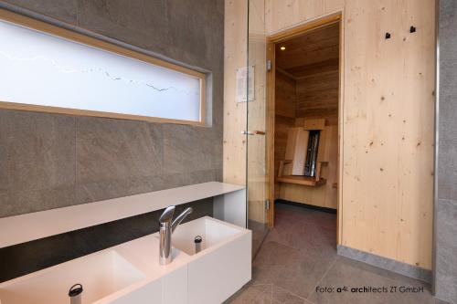 坦海姆Apart & Pension Wassermann inklusive Sommerbergbahnticket的一间带水槽和镜子的浴室