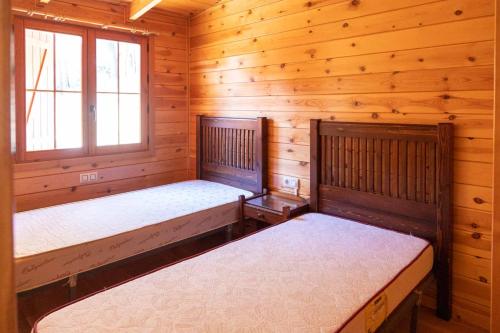 MinglanillaALBERGUE CONTRERAS的小木屋内一间卧室,配有两张床
