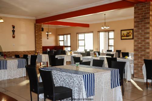 NqutuMeet Mekaar Resorts - Nquthu Hotel的用餐室配有桌椅和白色及蓝色床单