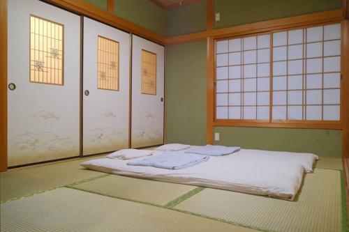 四万十市四万十川傍にある日本家屋まるごと「貸切宿　ほとり」的一间设有床铺的卧室,位于带窗户的房间内