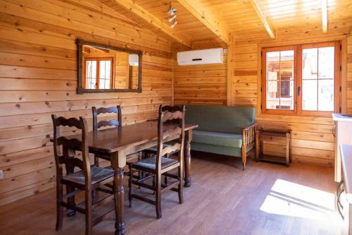 MinglanillaALBERGUE CONTRERAS的小木屋内的用餐室,配有桌椅