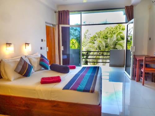 尼甘布尼甘布全景旅馆的一间卧室设有一张大床和大窗户