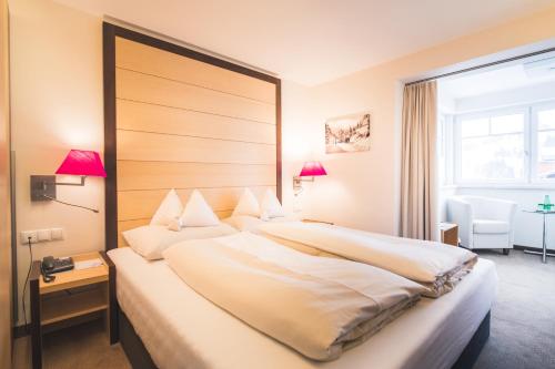 上陶恩Hotel Enzian - Adults Only的一张位于酒店客房的大床,设有窗户