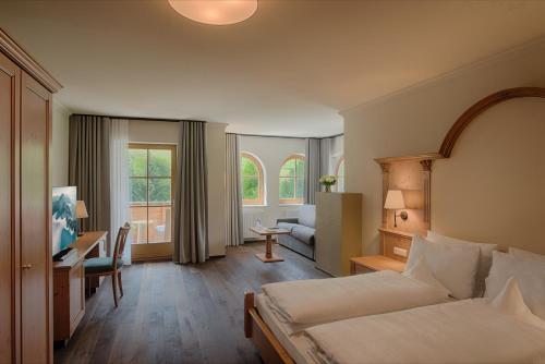 瓦尔奥纳的圣乔凡尼Naturhotel MOLIN的配有一张床和一张书桌的酒店客房