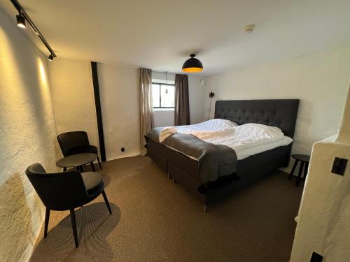 斯塔德Backadal Gård BnB的一间卧室配有一张床和两把椅子