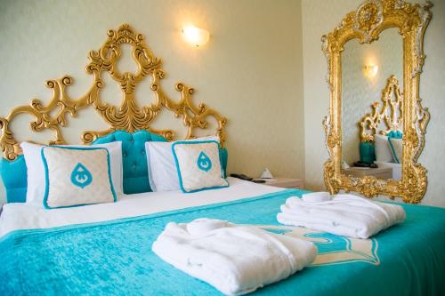 凯麦尔Daima Biz Hotel - Dolusu Aquapark Access的一间卧室配有一张蓝色的床,配有金色的框架