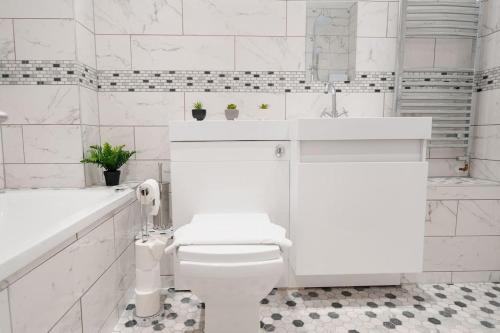 伯肯黑德Prenton House, 3BR Close to Liverpool的白色的浴室设有卫生间和水槽。