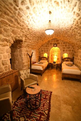 马尔丁Hanedan Konağı Butik Otel Deluxe Double Room With Turkish Bath By Bero的客房设有两张床、一张沙发和一张桌子。
