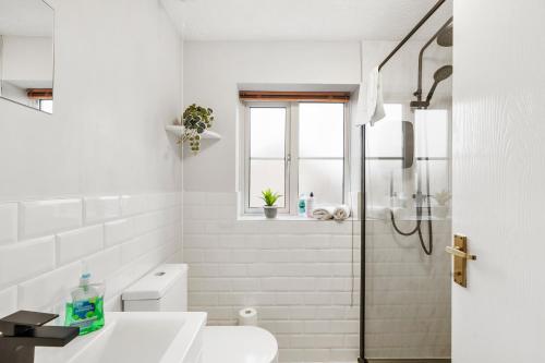 贝德福德Stunning Detached 3 Bed House - Parking & Garden的带淋浴和盥洗盆的白色浴室