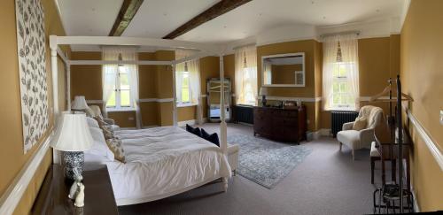 莱明斯特Winsley Park Farm的一间带天蓬床的卧室和一间客厅