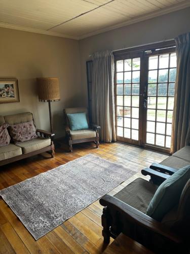 布隆方丹New Joy的客厅配有沙发、椅子和地毯