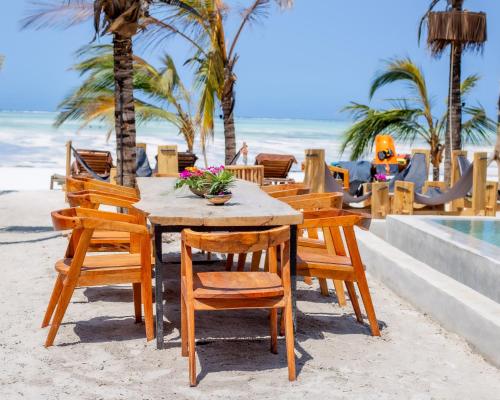帕杰The Nest Boutique Resort的海滩上的一张木桌和椅子