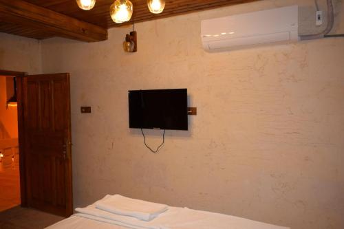 尚勒乌尔法Hasan Paşa Konuk Evi的卧室设有壁挂式电视和床。