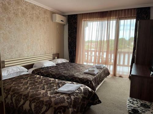 基尔科沃Ваканционно селище Романтика的酒店客房设有两张床和窗户。