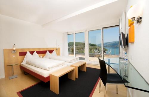 施皮茨Hotel Seaside的一间卧室配有一张床、一张桌子和一个窗户。