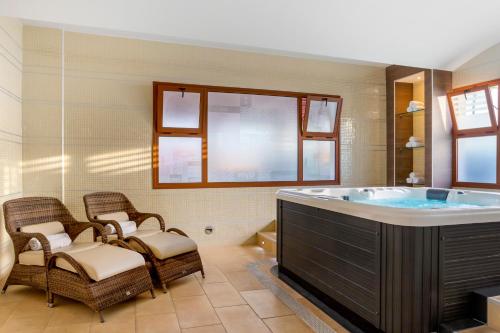 圣米格尔德阿沃纳钻石度假酒店皇家特内里费岛乡村俱乐部的一间带大浴缸及藤椅的浴室