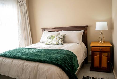 约翰内斯堡Greymont Luxury Apartments w Backup Inverter, Unlimited 100Mpbs WiFi的一间卧室配有一张带绿毯的床