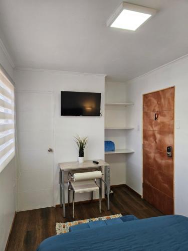 圣地亚哥Guest House Club Hípico的一间卧室配有书桌和桌椅