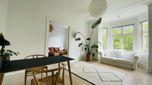 哥本哈根ApartmentInCopenhagen Apartment 1563的客厅配有桌子和沙发