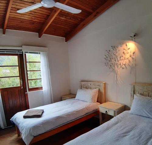 自然谷Stok&Hoed的一间卧室设有两张床和窗户。