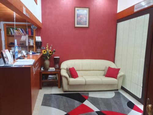 AcriHotel Ristorante Supersonik的带沙发和红色墙壁的客厅