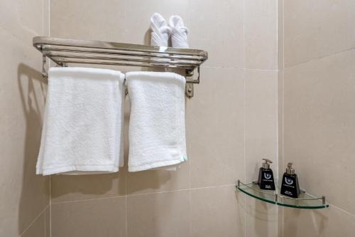 胡志明市Shogun Hotel的浴室设有挂在架子上的白色毛巾