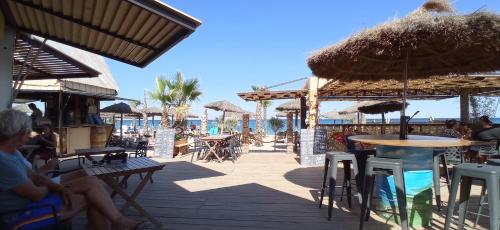 滨海阿热莱斯HappyMobilhome Argelès-sur-mer -plage à 500m- Camping 4 étoiles Del Mar的海滩上带桌子和遮阳伞的庭院