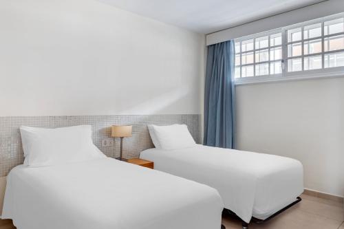 圣米格尔德阿沃纳圣巴巴拉高尔夫及海洋俱乐部钻石度假酒店的带窗户的客房内的2张白色床