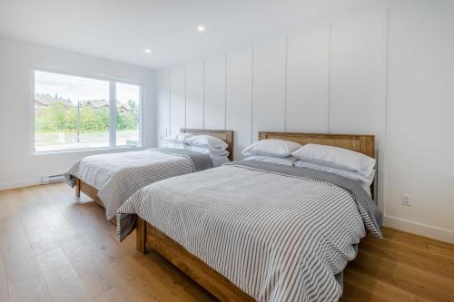 博普雷SOFA VILLAS MONT SAINTE-ANNE的白色客房的两张床,设有窗户