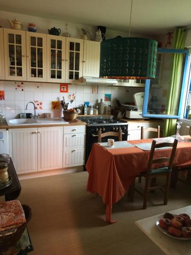 蒙德维尔Chambre spacieuse et lumineuse的厨房配有白色橱柜和桌子
