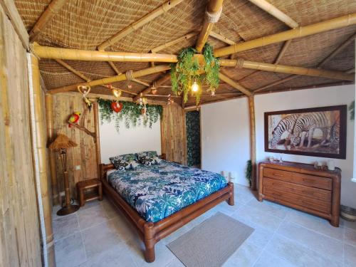 勒博塞Mas des rochers - Case bambou的一间卧室设有一张床和木制天花板