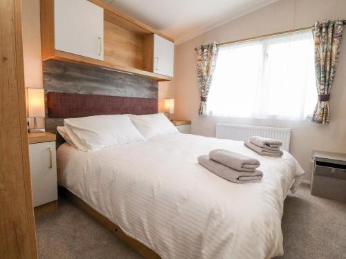 斯基普顿31 Willows的卧室配有白色床和毛巾
